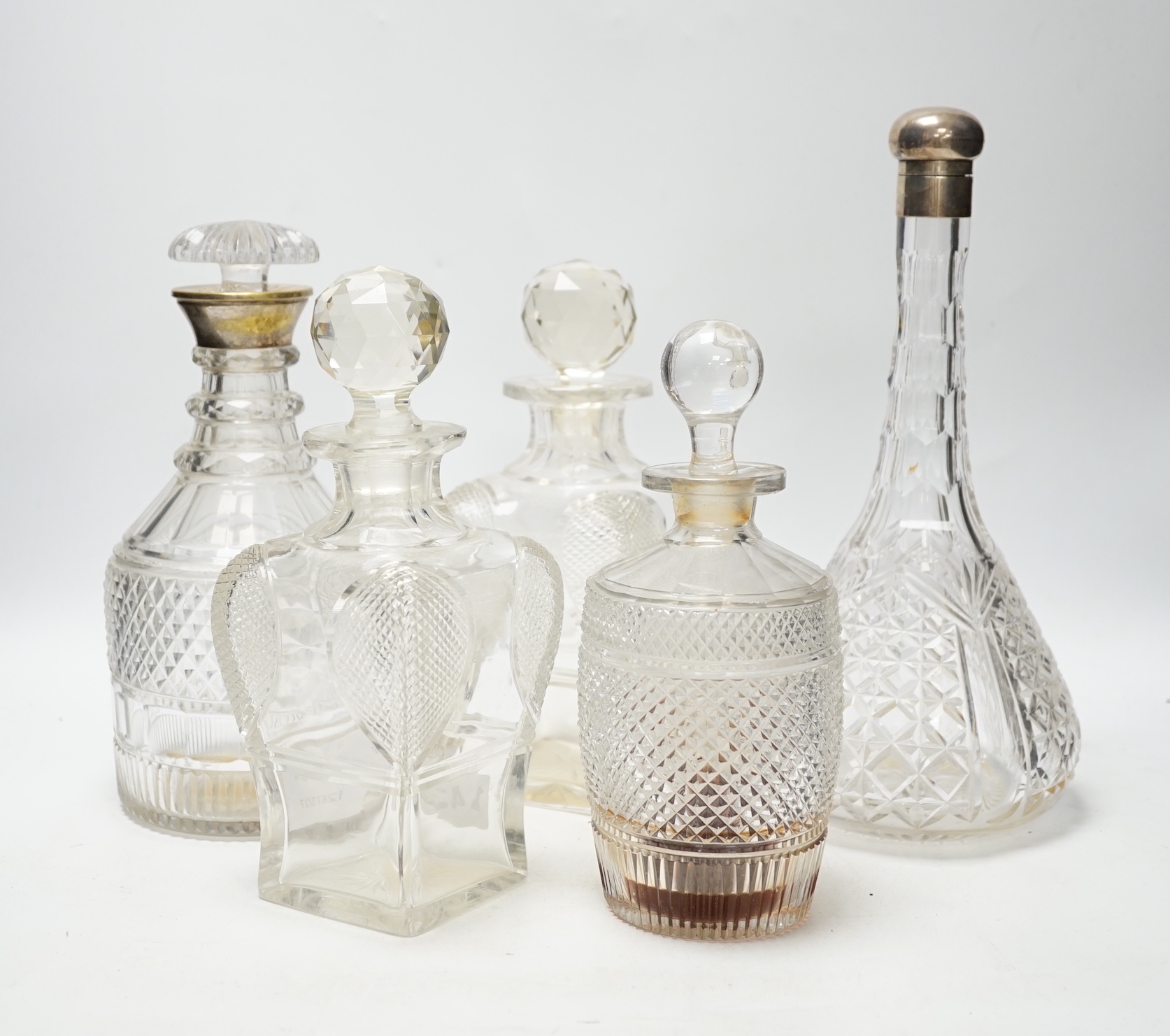 Two silver mounted glass decanters, a pair of waisted cut glass decanters and one other, tallest 29cm high (5)